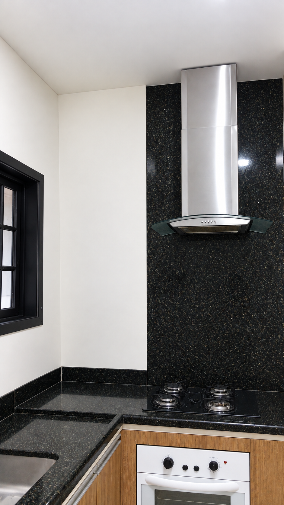 Cozinha com bancada em granito e coifa em inox