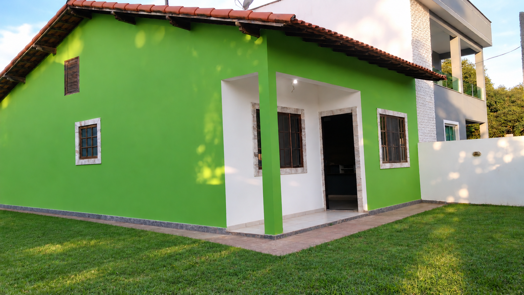 Fachada da residência pintada em verde e branco